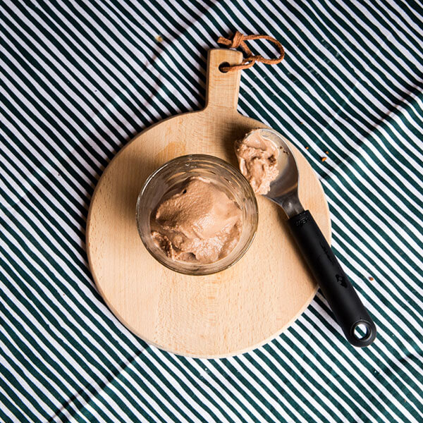 Chocolate ice-cream in a glass with a spoon on the right side